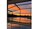 Beautiful sunset reflecting on the lake, viewed from the home's screened in lanai and private pool at 2911 Sunset Vista Ct, Kissimmee, FL 34747