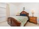 Well-lit bedroom with wooden furniture and a leafy patterned comforter at 8169 Fan Palm Way, Kissimmee, FL 34747