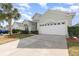 One-story house with a two-car garage, palm trees, and well-manicured lawn at 8169 Fan Palm Way, Kissimmee, FL 34747