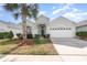 One-story house with a two-car garage, palm trees, and well-manicured lawn at 8169 Fan Palm Way, Kissimmee, FL 34747