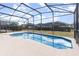 Enclosed rectangular pool with a concrete deck at 8169 Fan Palm Way, Kissimmee, FL 34747