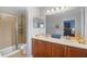 Bathroom featuring dual sinks, wood cabinets, and glass-enclosed shower at 207 Maplebrook Dr, Altamonte Springs, FL 32714