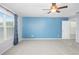 Large bedroom features neutral carpet, blue accent wall, ceiling fan, and natural light from the window at 207 Maplebrook Dr, Altamonte Springs, FL 32714