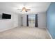 Spacious bedroom with neutral carpet, ceiling fan, TV, walk-in closet and large window at 207 Maplebrook Dr, Altamonte Springs, FL 32714