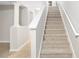 A carpeted staircase with white banister and supports offers access to the upper level of the home at 207 Maplebrook Dr, Altamonte Springs, FL 32714
