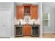 Built-in wine bar features wooden cabinets, wine rack, beverage coolers, granite countertop, and sink at 207 Maplebrook Dr, Altamonte Springs, FL 32714