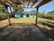 Backyard view from under the covered patio, showcasing solar panels and a grassy area at 5018 Figwood Ln, Orlando, FL 32808