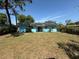 The backyard has solar panels on the roof, a sliding glass door, and a large grassy area at 5018 Figwood Ln, Orlando, FL 32808
