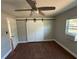 This bedroom has barn door access to closet, wood-look floors, and a ceiling fan at 5018 Figwood Ln, Orlando, FL 32808
