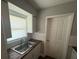A bright kitchen featuring white cabinets, wood countertops, stainless sink, window and tile backsplash at 5018 Figwood Ln, Orlando, FL 32808