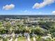 Expansive aerial shot featuring a lakefront residential area with mature trees and community amenities at 5240 N Lake Burkett Ln, Winter Park, FL 32792