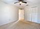 Neutral bedroom featuring carpet, a ceiling fan, and a closet with louvered doors at 5240 N Lake Burkett Ln, Winter Park, FL 32792