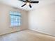 Bright bedroom with large window, neutral carpet, and ample natural light at 5240 N Lake Burkett Ln, Winter Park, FL 32792