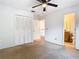 Bright bedroom featuring a ceiling fan, a closet, neutral carpet and an adjacent bathroom at 5240 N Lake Burkett Ln, Winter Park, FL 32792