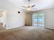 Carpeted bedroom with vaulted ceiling and sliding glass doors to the patio at 5240 N Lake Burkett Ln, Winter Park, FL 32792