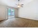 Bedroom with carpeted floor, sliding glass door, and a ceiling fan at 5240 N Lake Burkett Ln, Winter Park, FL 32792