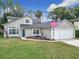 Charming two-story home with a well-manicured lawn and an American flag waving in the breeze at 5240 N Lake Burkett Ln, Winter Park, FL 32792