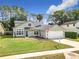 Well-manicured home featuring a lush green lawn and inviting front facade, perfect for a Gathering or individual at 5240 N Lake Burkett Ln, Winter Park, FL 32792