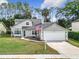 Charming two-story home with a well-manicured lawn and an attached two-car garage at 5240 N Lake Burkett Ln, Winter Park, FL 32792