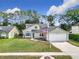 Charming two-story home featuring a well-manicured lawn and a classic design with a two-car garage at 5240 N Lake Burkett Ln, Winter Park, FL 32792