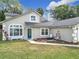 Inviting front yard with lush green grass and a well-maintained exterior featuring a charming entryway and manicured landscaping at 5240 N Lake Burkett Ln, Winter Park, FL 32792