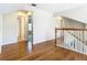 Upstairs hallway featuring hardwood floors and white walls, leading to various rooms at 5240 N Lake Burkett Ln, Winter Park, FL 32792