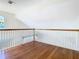 Hardwood landing area with white railings, offering a bright and open space at 5240 N Lake Burkett Ln, Winter Park, FL 32792