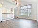 Bright living room featuring tall ceilings, hardwood floors, and large windows with sheer curtains at 5240 N Lake Burkett Ln, Winter Park, FL 32792