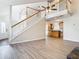 Bright living room with hardwood floors, staircase, and open floor plan to the kitchen at 5240 N Lake Burkett Ln, Winter Park, FL 32792