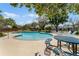 Community pool featuring lounge chairs, picnic tables, and a shallow end with landscaped trees surrounding the area at 5240 N Lake Burkett Ln, Winter Park, FL 32792