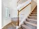 Elegant foyer featuring a staircase with a white banister, wood handrail, and decorative front door at 5240 N Lake Burkett Ln, Winter Park, FL 32792