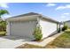 Two-car garage of home featuring light-grey paint, a concrete driveway, and maintained landscaping at 1533 Loch Avich Rd, Winter Garden, FL 34787