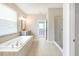 Bright bathroom featuring a soaking tub, tiled floors, glass enclosed shower and large vanity at 2781 Sand Oak Loop, Apopka, FL 32712