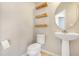 Modern powder room with floating wood shelves and a pedestal sink at 2781 Sand Oak Loop, Apopka, FL 32712