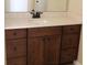 Bathroom with dark wood cabinets, light colored countertop, and dark plumbing fixtures at 3621 Arlington Ridge Blvd, Leesburg, FL 34748