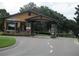 Gated community entrance with stone pillars and a welcoming landscape design and flowers at 3621 Arlington Ridge Blvd, Leesburg, FL 34748