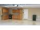 Spacious garage featuring built-in cabinets, epoxy flooring, and a white door at 3621 Arlington Ridge Blvd, Leesburg, FL 34748