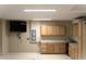 Large garage with storage cabinets, TV, utility box, and epoxy flooring at 3621 Arlington Ridge Blvd, Leesburg, FL 34748