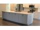 Kitchen island featuring a sink and plenty of storage with modern appliances at 3621 Arlington Ridge Blvd, Leesburg, FL 34748