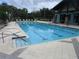 Community pool features a large swimming area with lane markers and a tiled pool deck with lounge chairs and a pool house at 3621 Arlington Ridge Blvd, Leesburg, FL 34748
