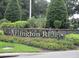 Community sign for Arlington Ridge nestled among manicured landscaping with colorful flowers and greenery at 3621 Arlington Ridge Blvd, Leesburg, FL 34748