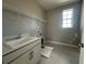 Functional laundry room with gray cabinets, sink, and a wire shelving system at 1342 Twelve Oaks Rd, Saint Cloud, FL 34771