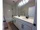 Bright bathroom featuring a double sink vanity, framed mirror, white cabinets, and a tiled shower and tub at 1366 Twelve Oaks Rd, Saint Cloud, FL 34771