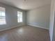 Bright, clean bedroom featuring wood-look flooring and lots of natural light from two large windows at 1366 Twelve Oaks Rd, Saint Cloud, FL 34771