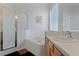 Bright bathroom with a walk-in shower, separate tub, and a single sink vanity with wood cabinets at 2601 Isla Vista Ct, Kissimmee, FL 34747