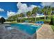 Inviting backyard pool with blue lounge chairs and manicured landscaping at 7647 Fairfax Dr, Kissimmee, FL 34747