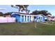 Blue house with white fence and a landscaped yard at 1347 W Wellington Dr, Deltona, FL 32725