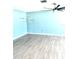 Spacious living room with light blue walls, wood-look flooring, and ceiling fan at 1347 W Wellington Dr, Deltona, FL 32725