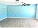 Living room with light blue walls, wood-look floors, and a large window at 1347 W Wellington Dr, Deltona, FL 32725