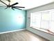 Living room with light blue walls, wood-look flooring, and ceiling fan at 1347 W Wellington Dr, Deltona, FL 32725